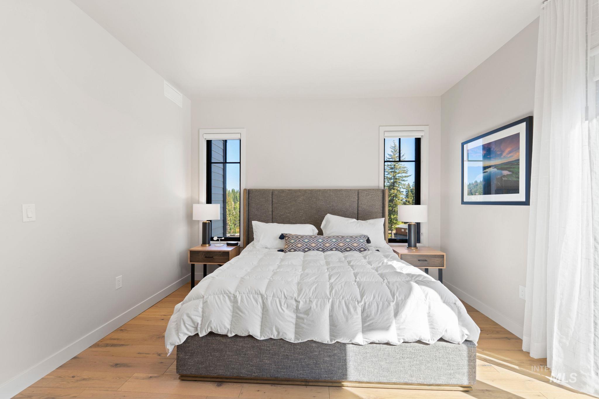 Bedroom with wood finished floors and baseboards