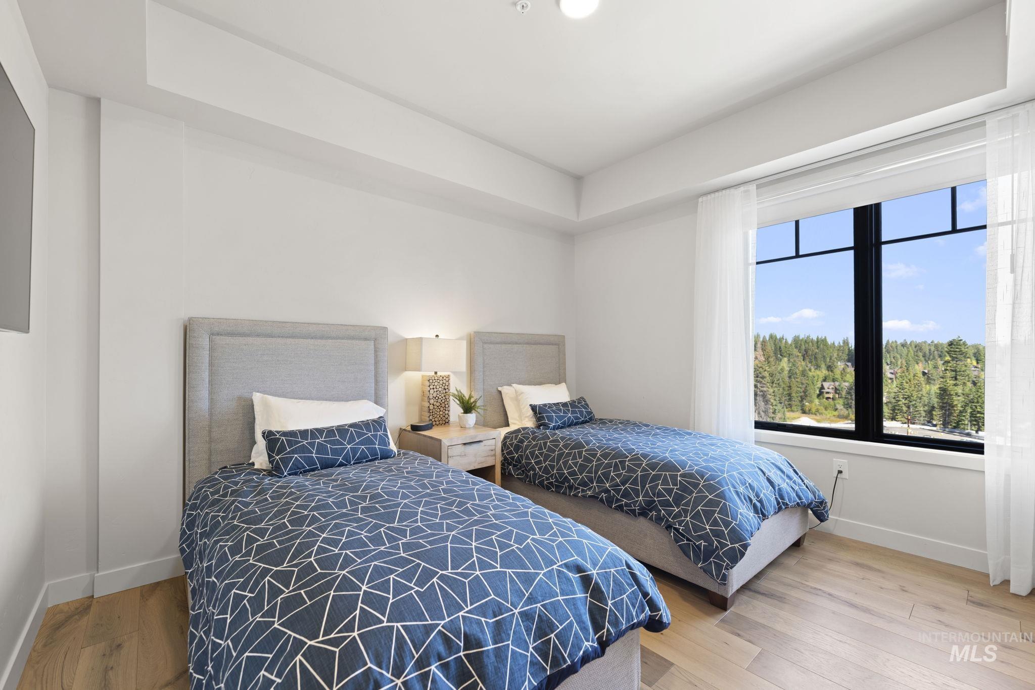 Bedroom featuring light wood finished floors and a tray ceiling