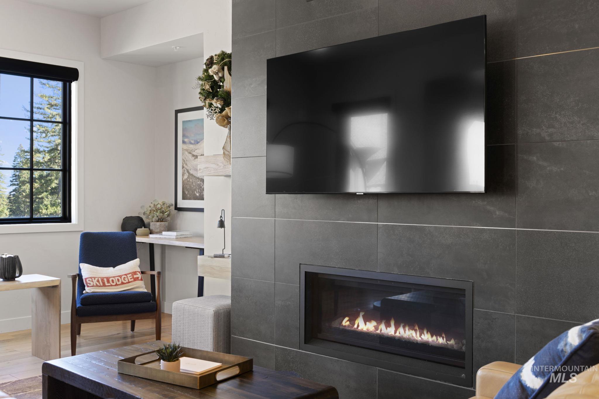 Living room with wood finished floors and a tile fireplace
