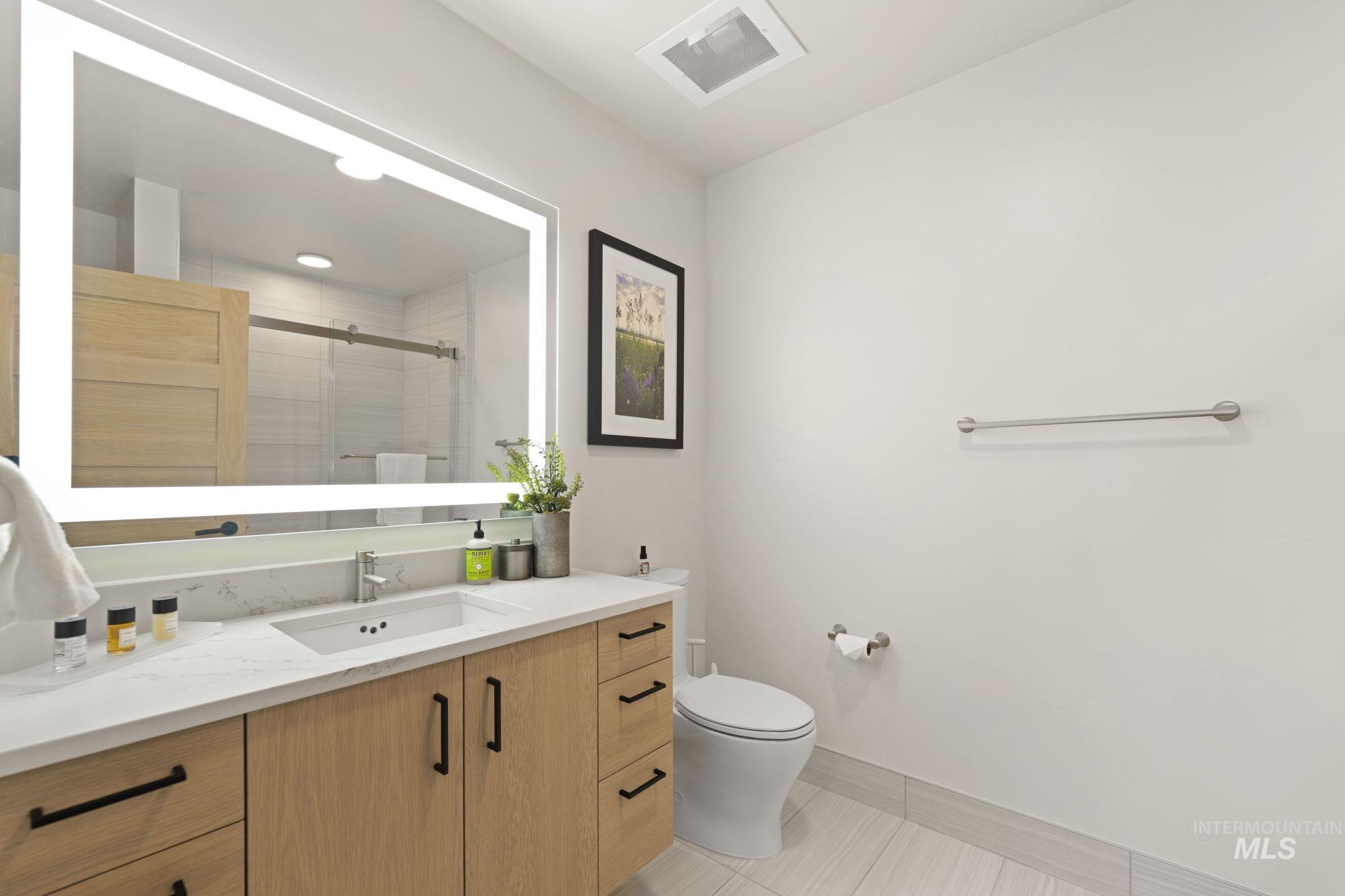Full bathroom with vanity, a stall shower, and light tile patterned floors