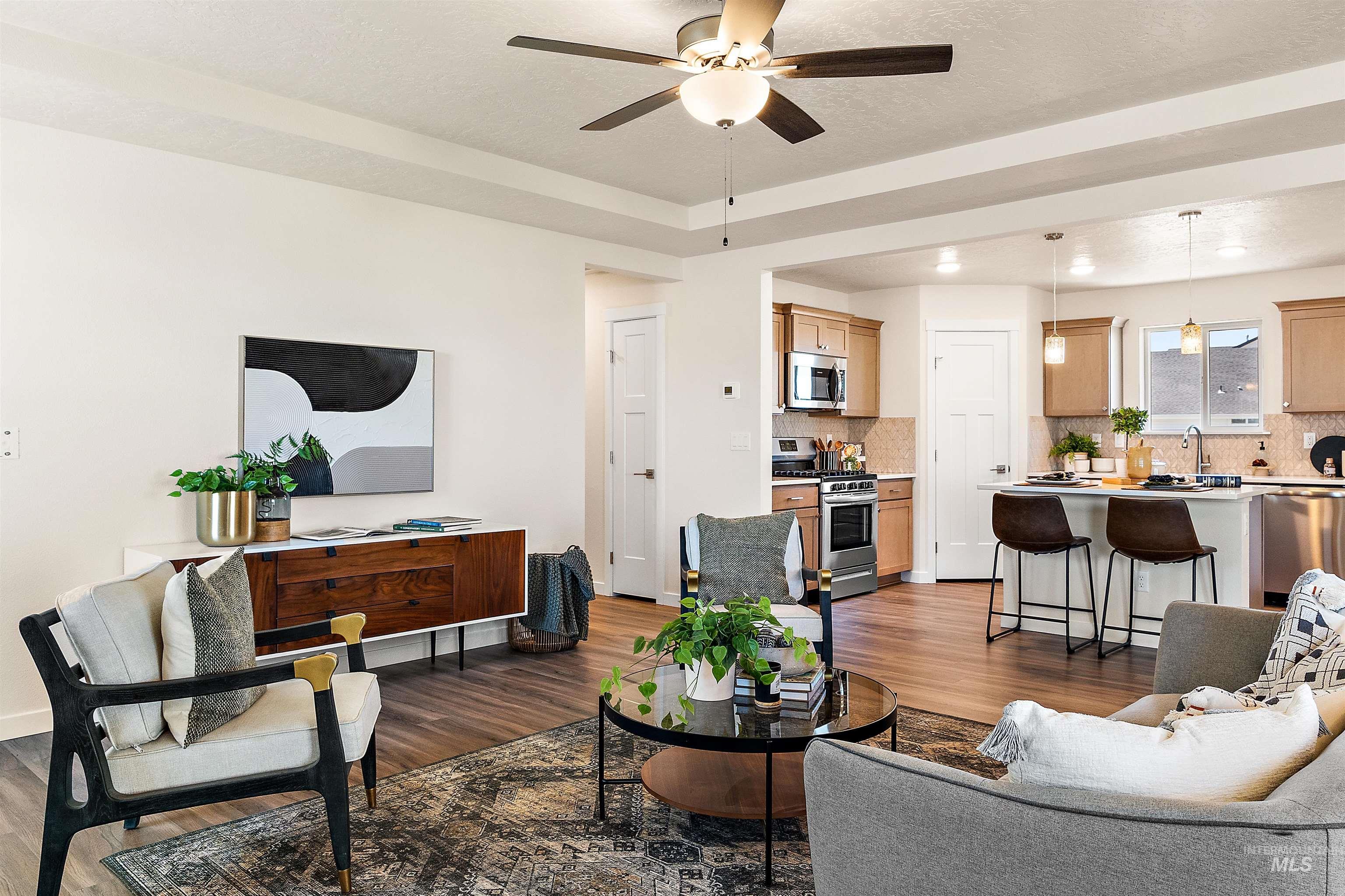 Living area featuring wood finished floors, a ceiling fan, and a textured ceiling