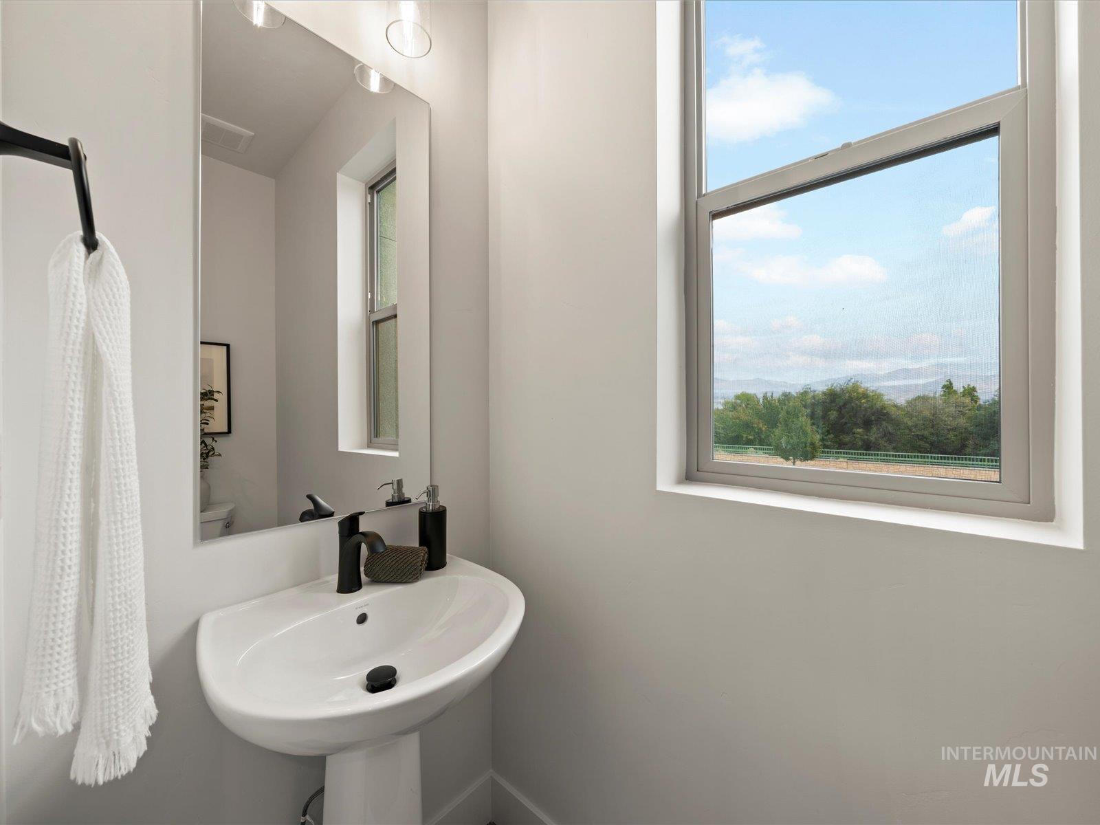 Half bathroom with a sink and baseboards