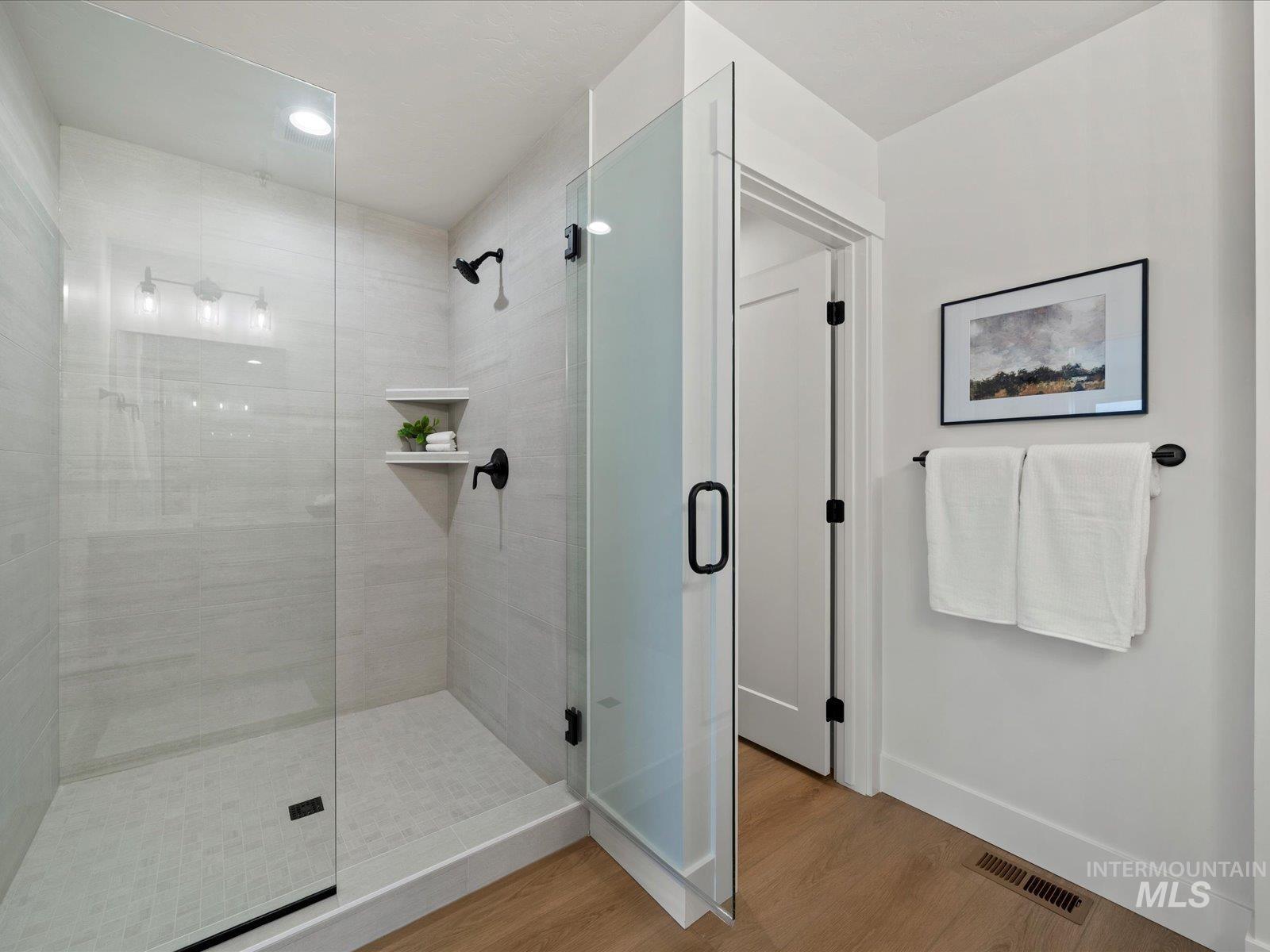 Full bath featuring a stall shower, wood finished floors, and recessed lighting