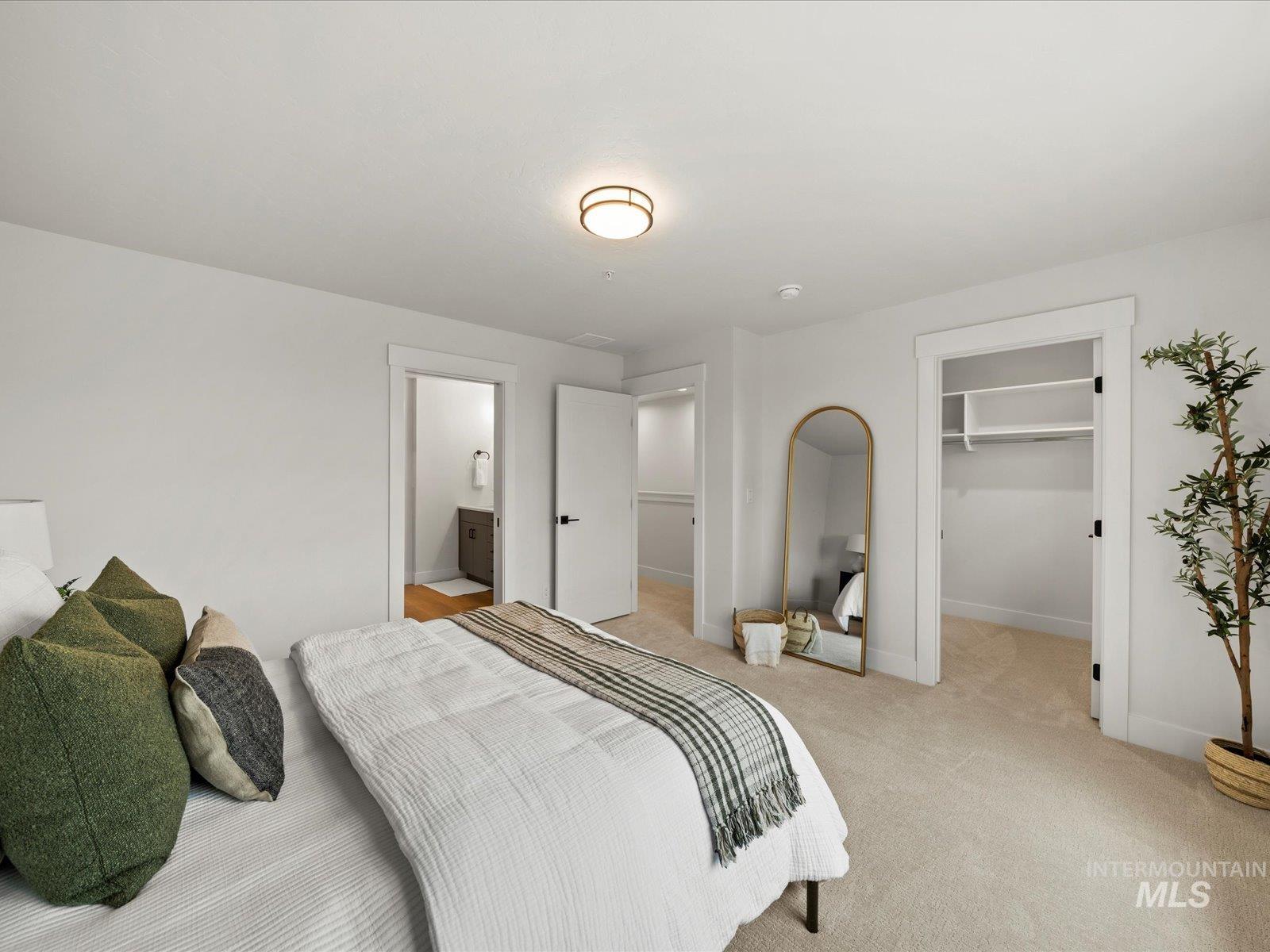 Carpeted bedroom with a spacious closet and ensuite bath