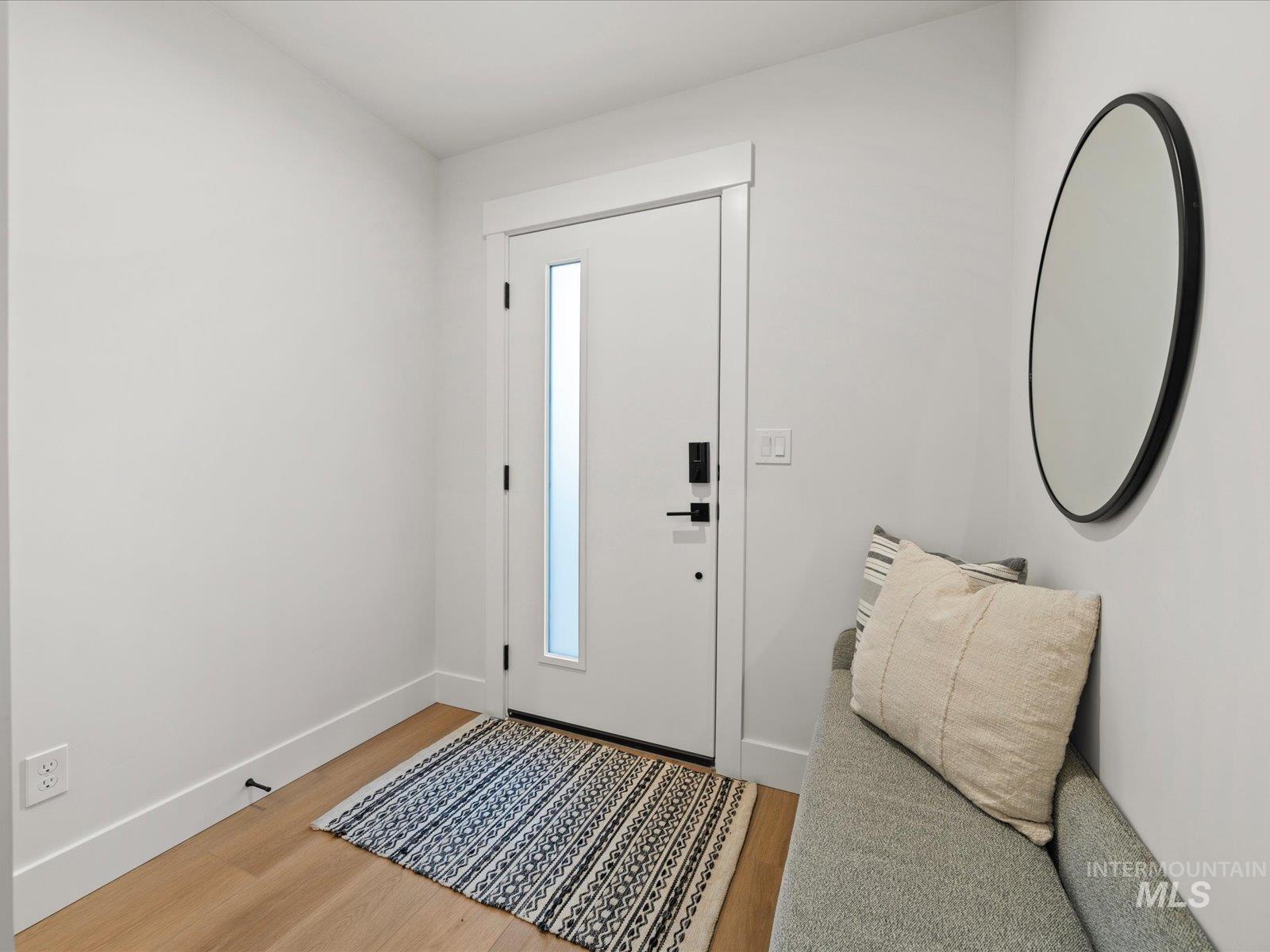 Foyer featuring light wood-style flooring and baseboards