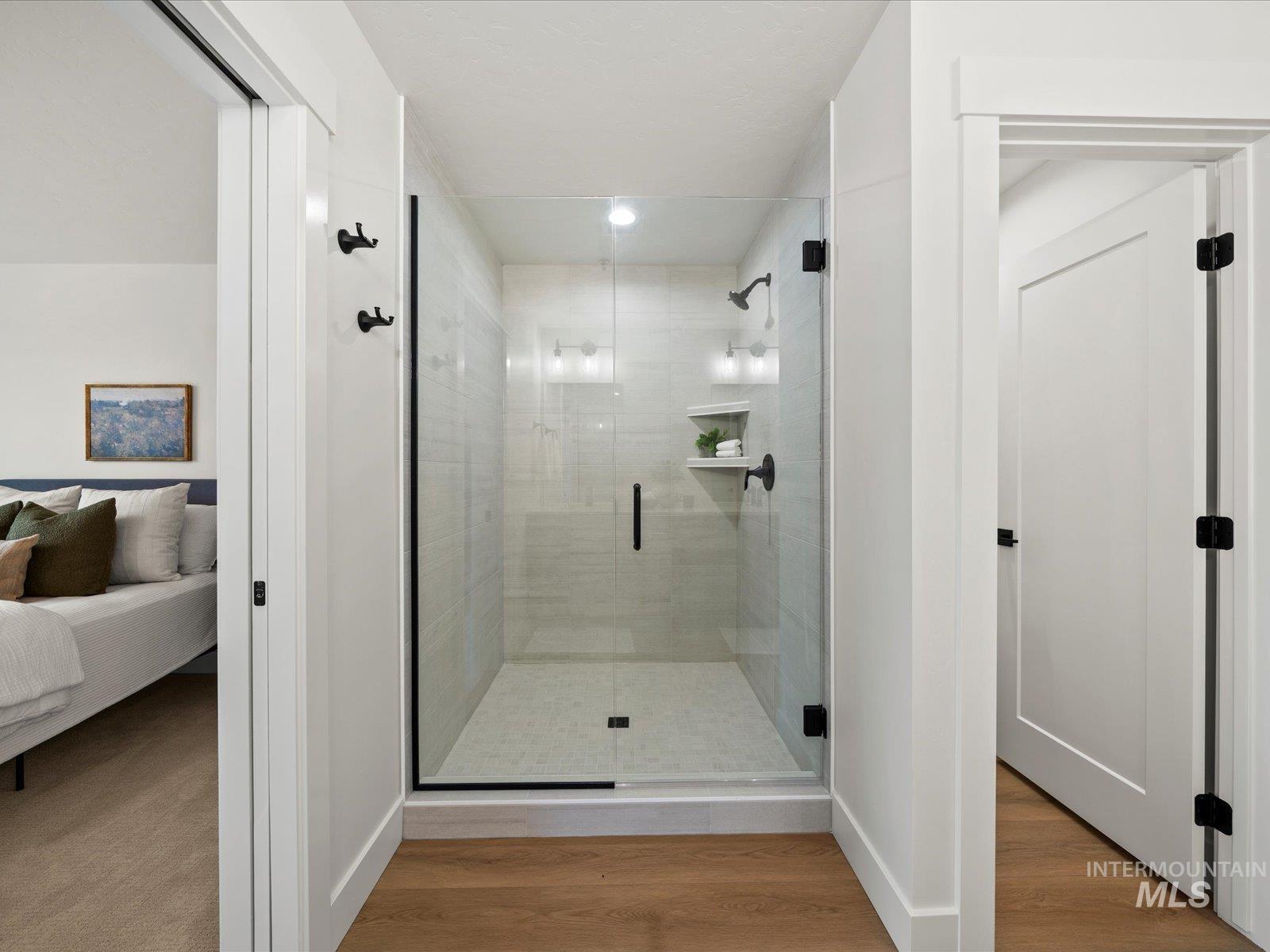 Ensuite bathroom with a shower stall, wood finished floors, and recessed lighting