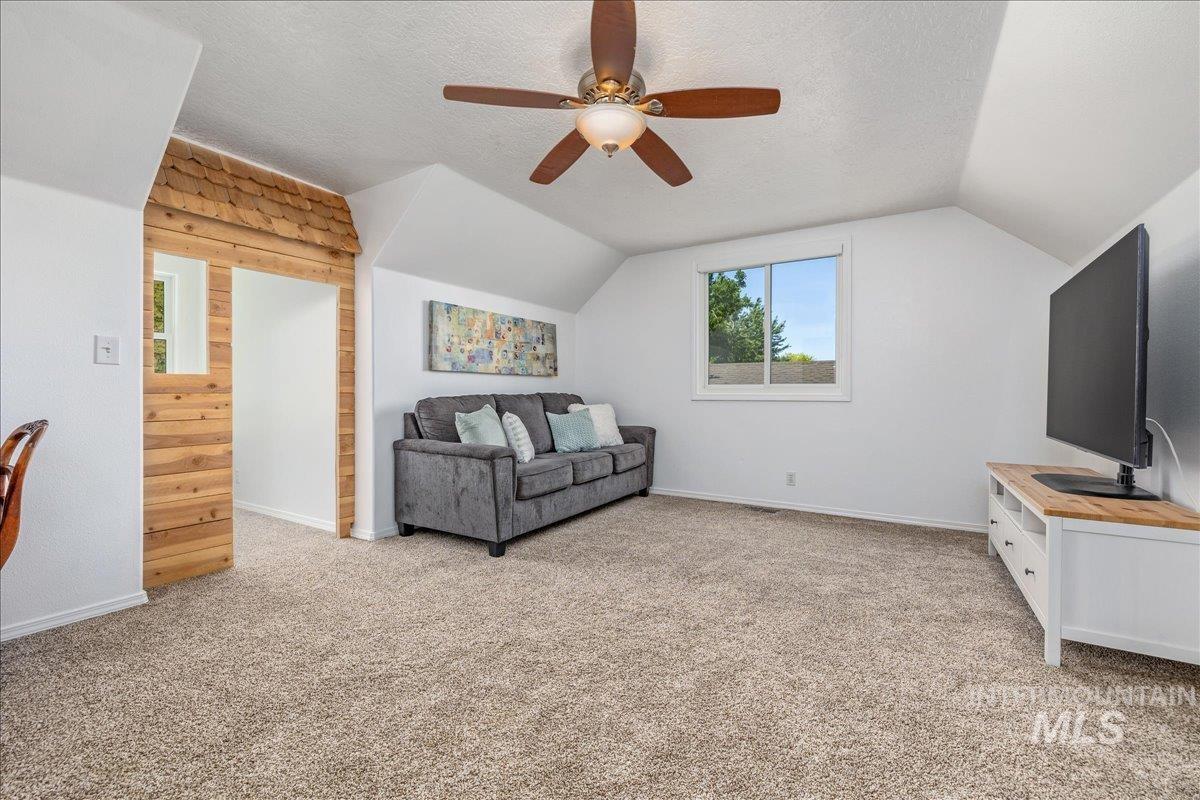 Carpeted room with a ceiling fan