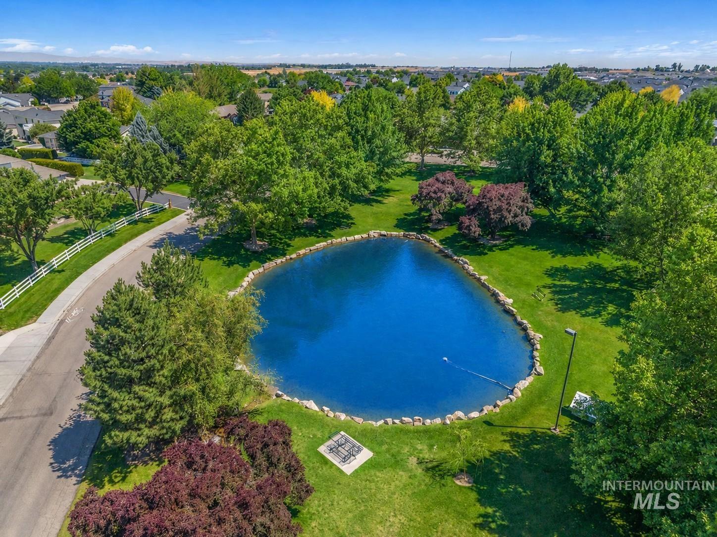 Manicured green space featuring a central pond with a stone border