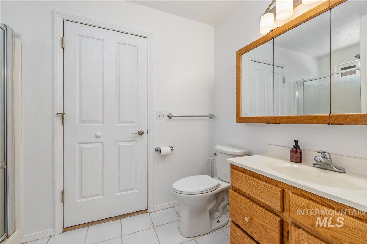 Bathroom with a wood-finish vanity, integrated sink, and medicine cabinet with overhead lighting
