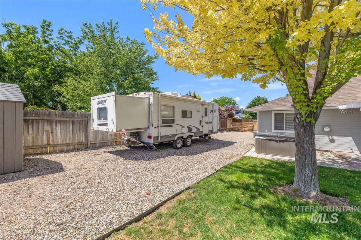 Dedicated gravel RV parking pad, wood fencing, and a storage shed