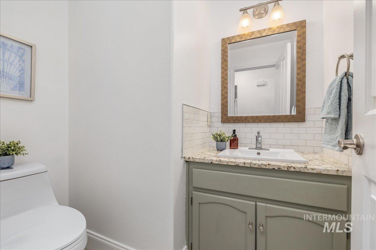 Bathroom vanity featuring a light-colored countertop, undermount sink, and a framed mirror