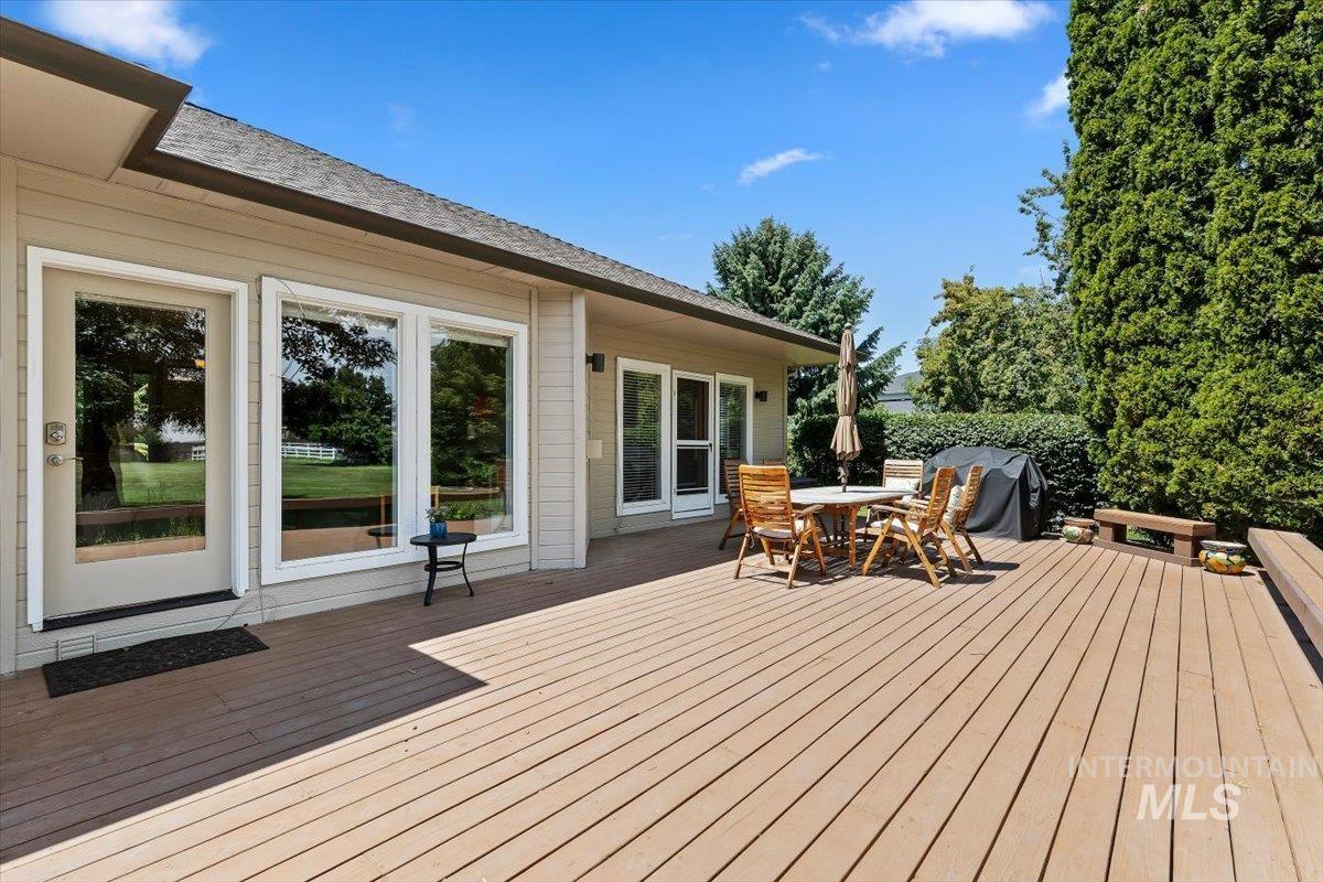 Expansive outdoor wood-finish deck with multiple access points to the residence