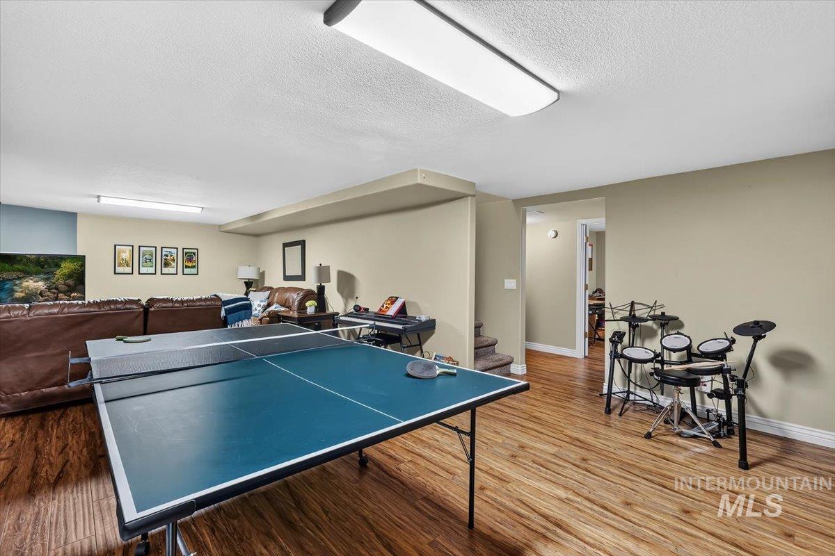 Open recreation space featuring wood-finish flooring and neutral wall tones