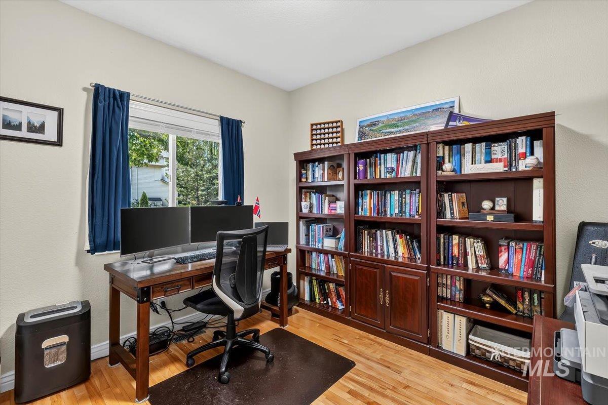 Interior room featuring warm-toned wood-finish flooring and light-toned walls