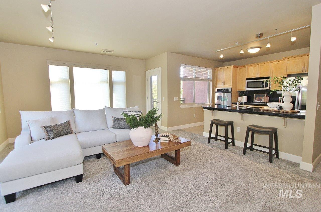 Living area with track lighting and light carpet
