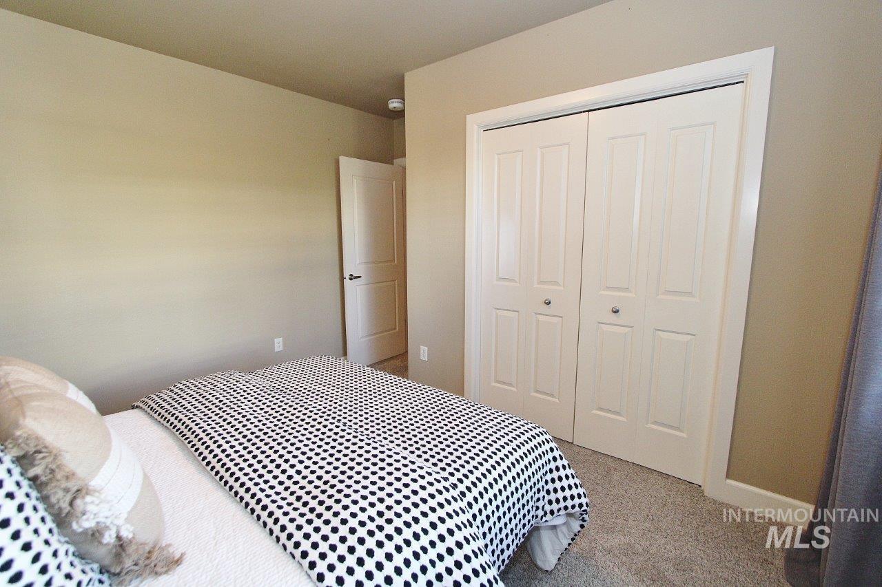 Carpeted bedroom with a closet and baseboards