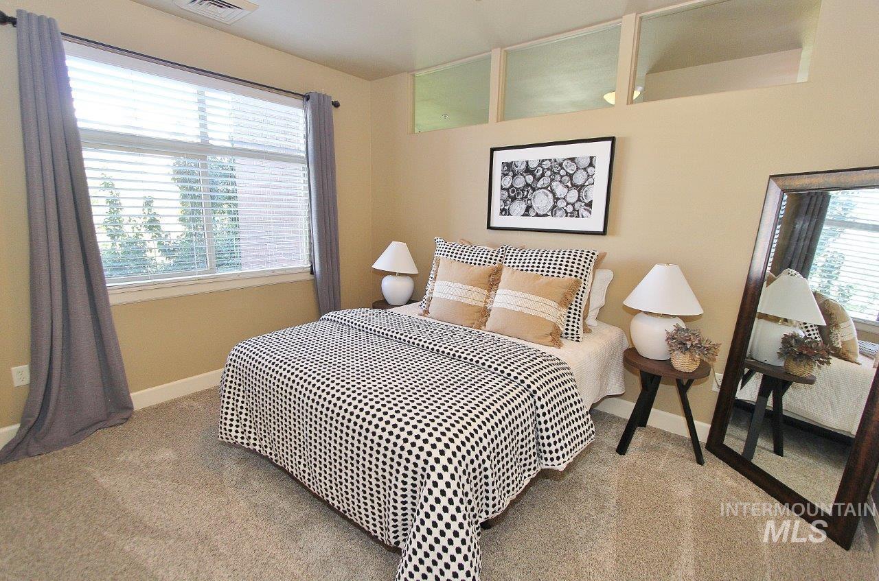 Bedroom featuring multiple windows and carpet flooring