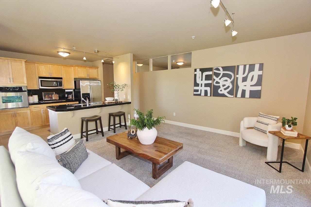 Living room with rail lighting and light colored carpet