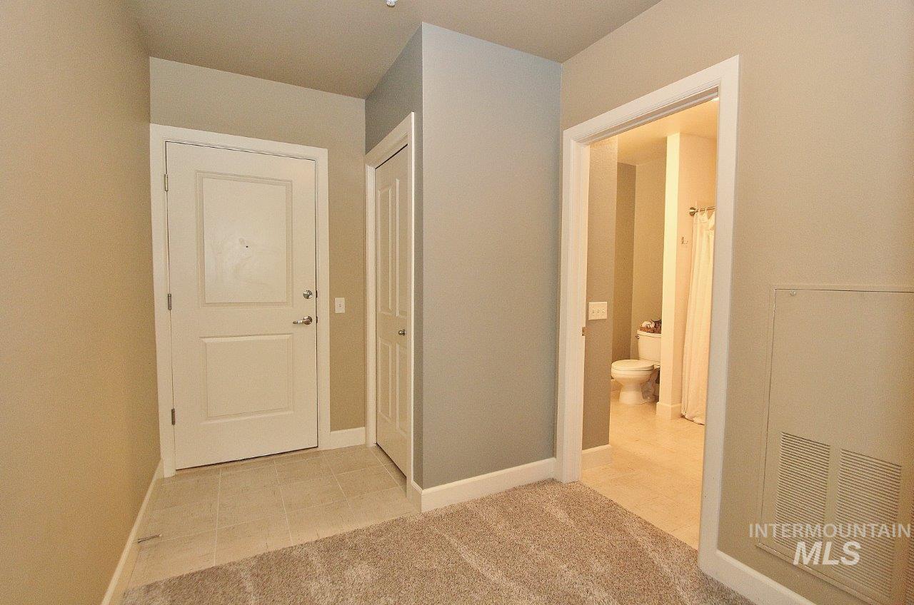 Hall with baseboards and light tile patterned floors