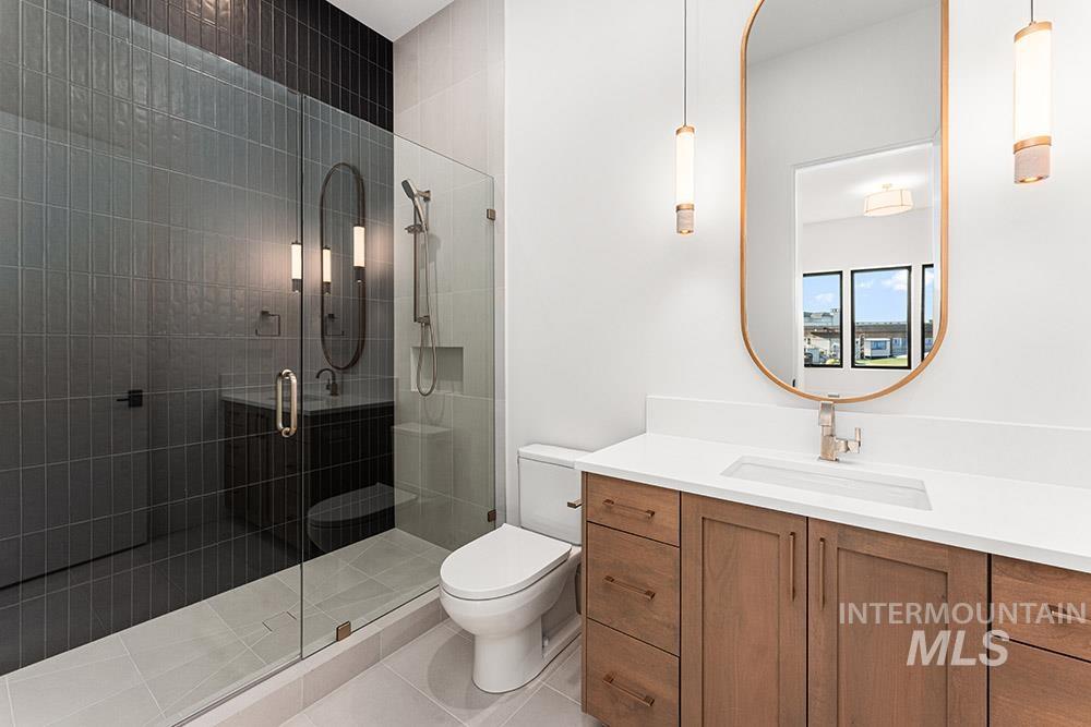 Bathroom featuring vanity, a stall shower, and light tile patterned flooring