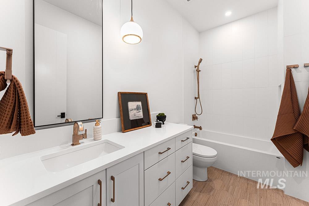 Full bath featuring vanity, light wood-style flooring, and bathing tub / shower combination
