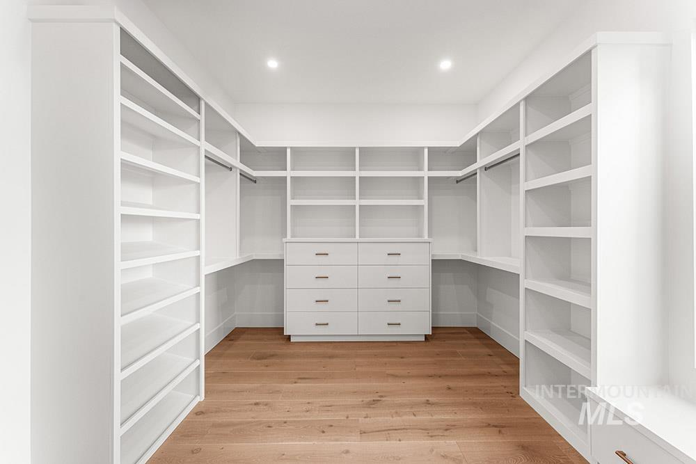 Walk in closet with light wood-type flooring