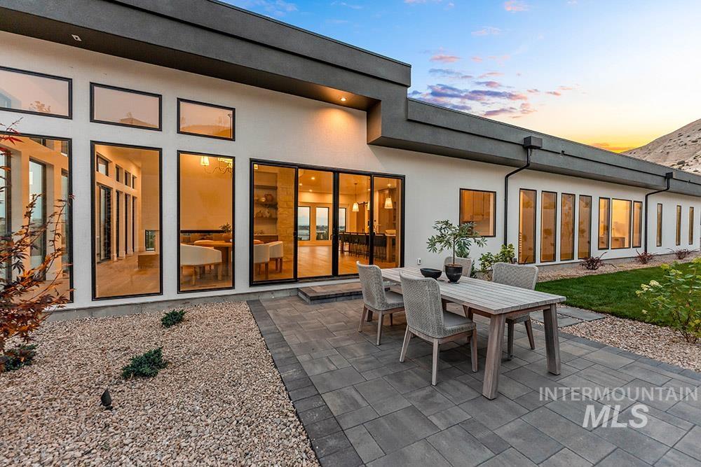 Back of house with outdoor dining area, stucco siding, and a patio area