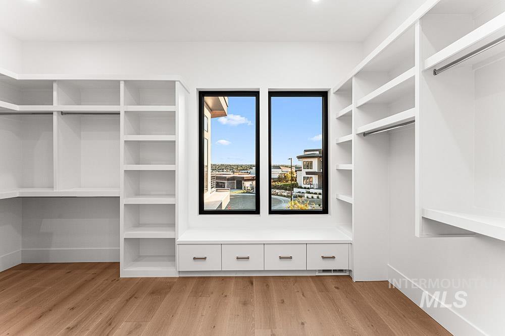 Walk in closet with light wood-type flooring