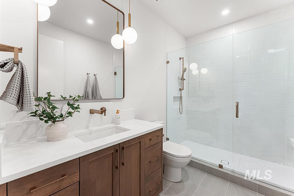 Bathroom with vanity, a shower stall, light tile patterned floors, and recessed lighting