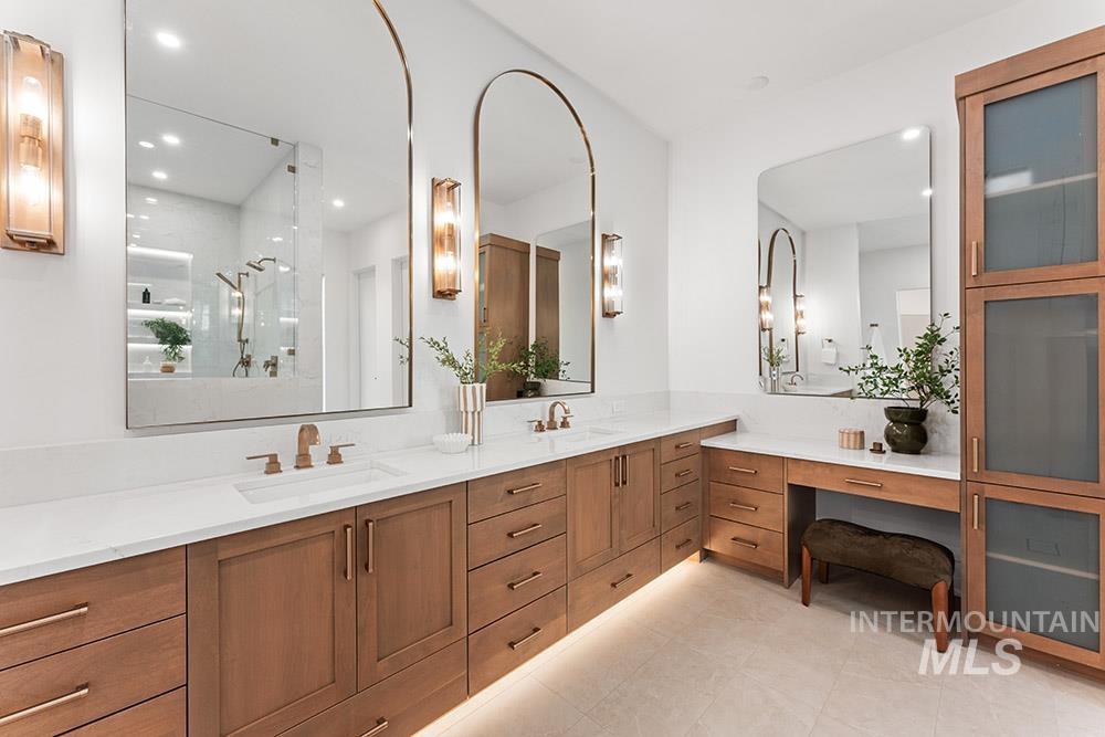 Bathroom featuring double vanity, a shower stall, and recessed lighting