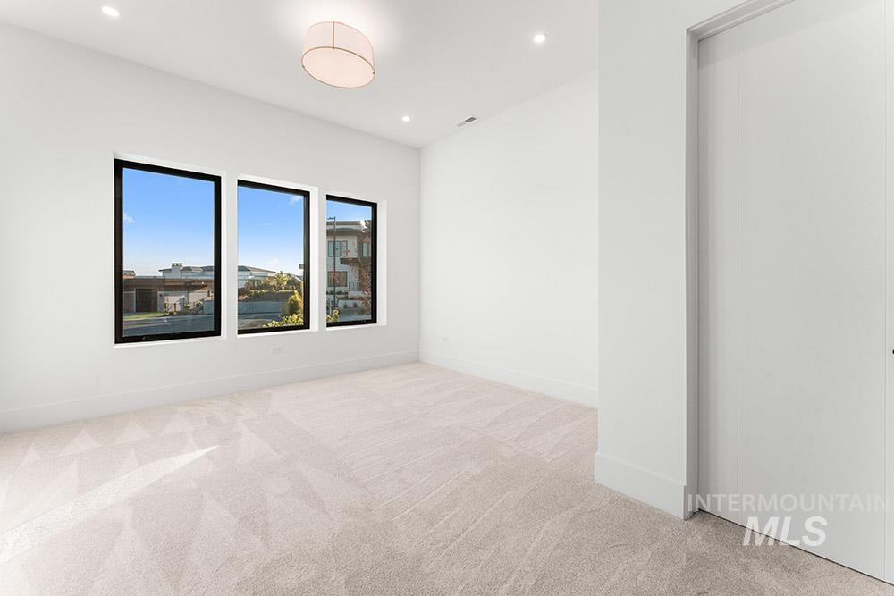 Spare room featuring light colored carpet and recessed lighting