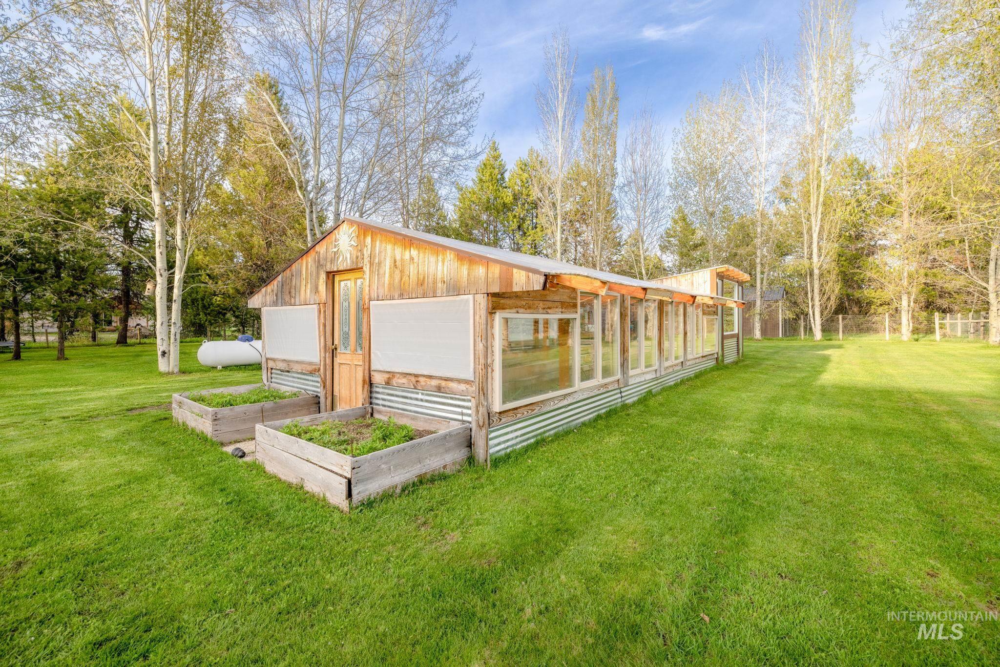 Exterior space with a lawn, a garden, view of wooded area, and a garage