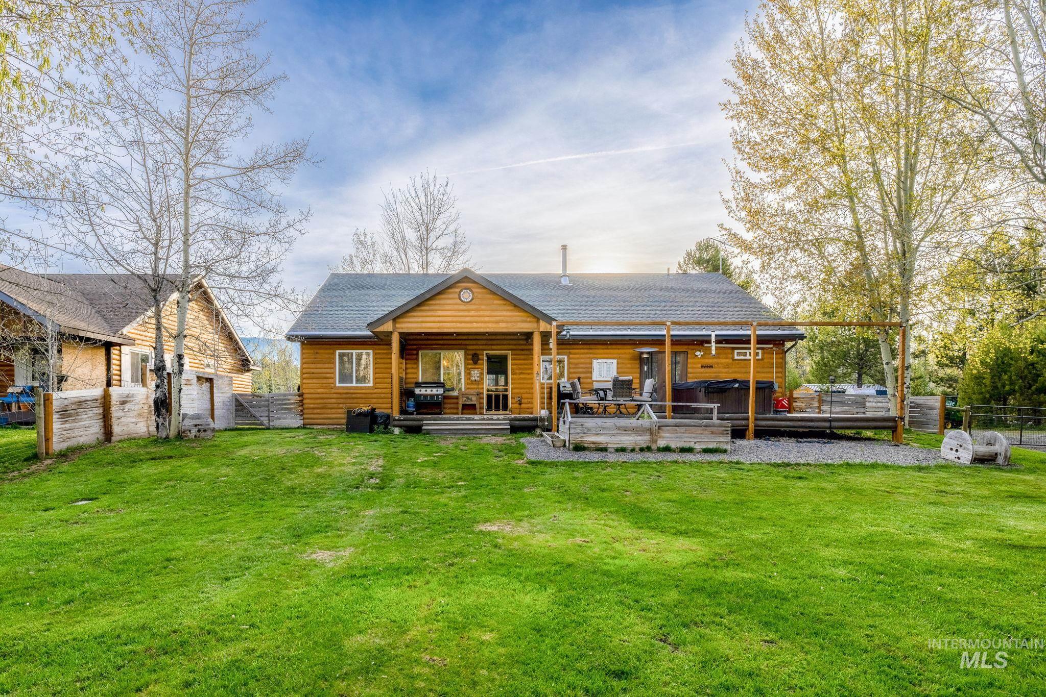 Back of house with a wooden deck, a hot tub, and a shingled roof