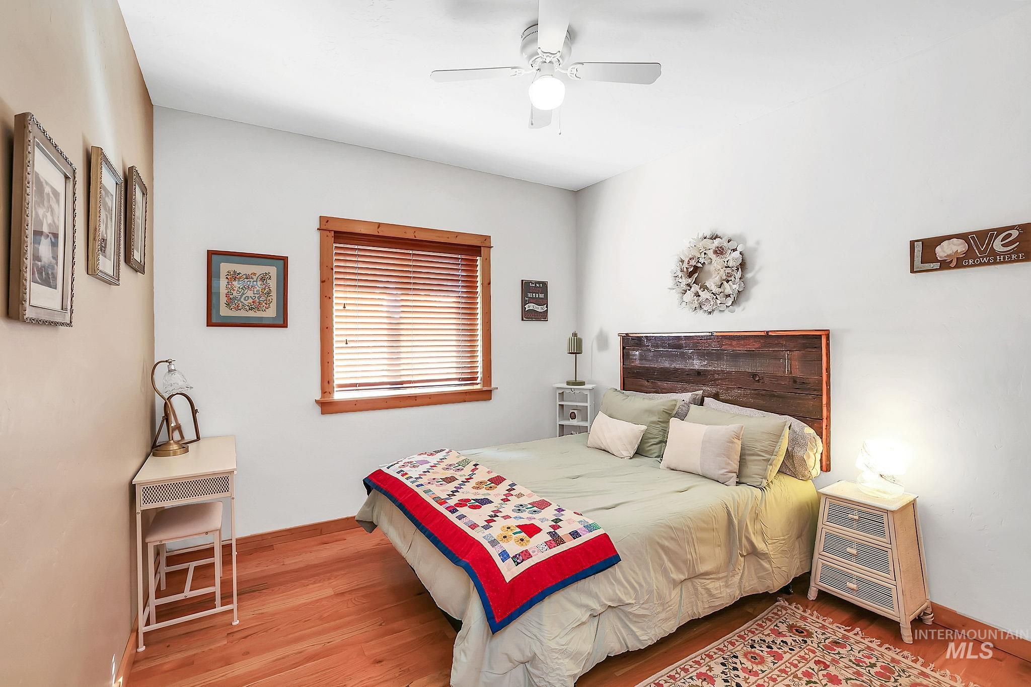 Bedroom with ceiling fan and light wood-style flooring