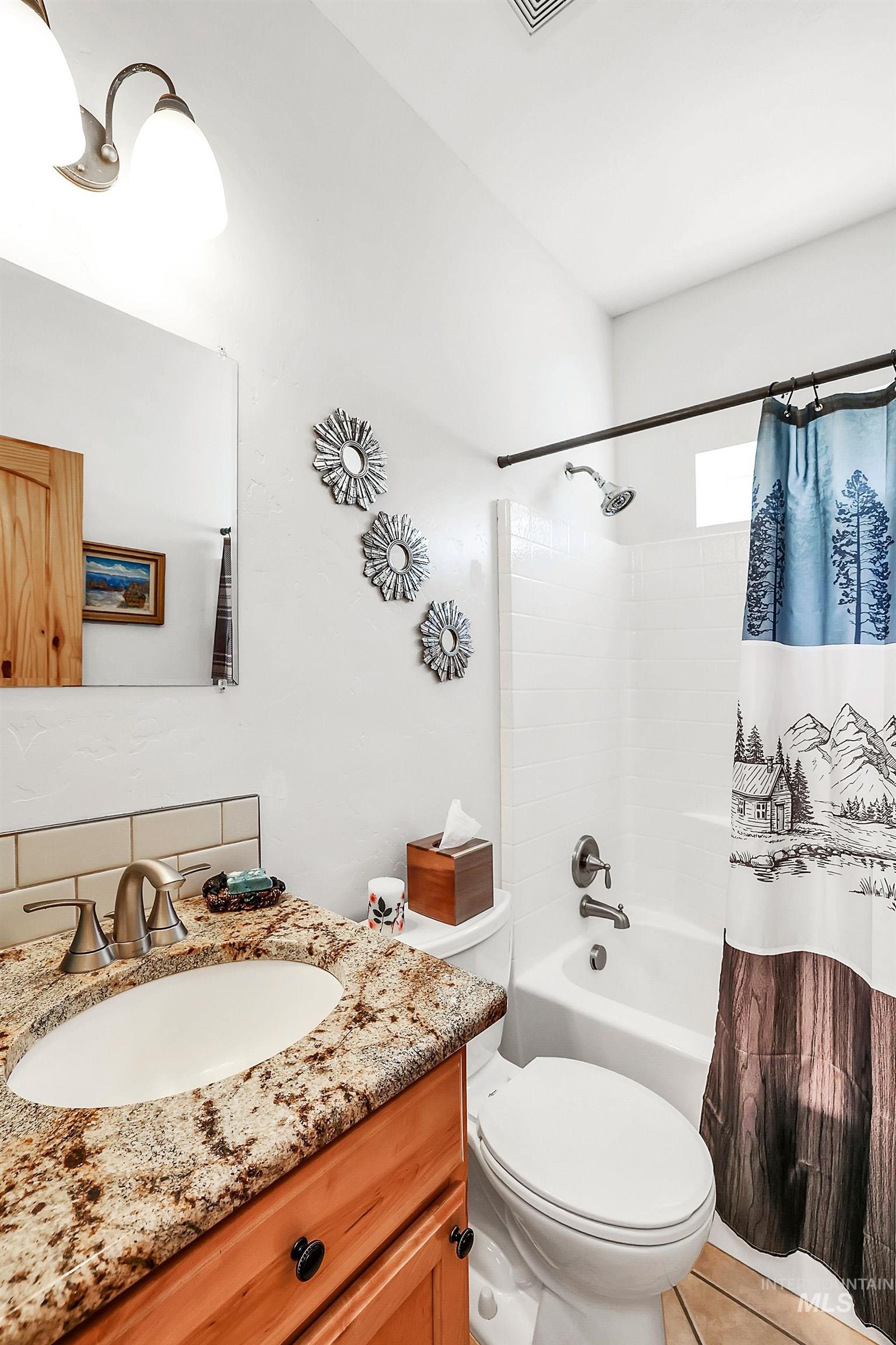 Bathroom with vanity and shower / bathtub combination with curtain