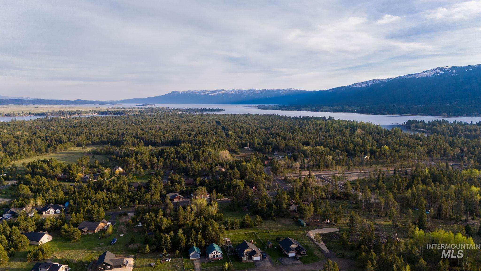 Drone / aerial view of a heavily wooded area and a water and mountain view