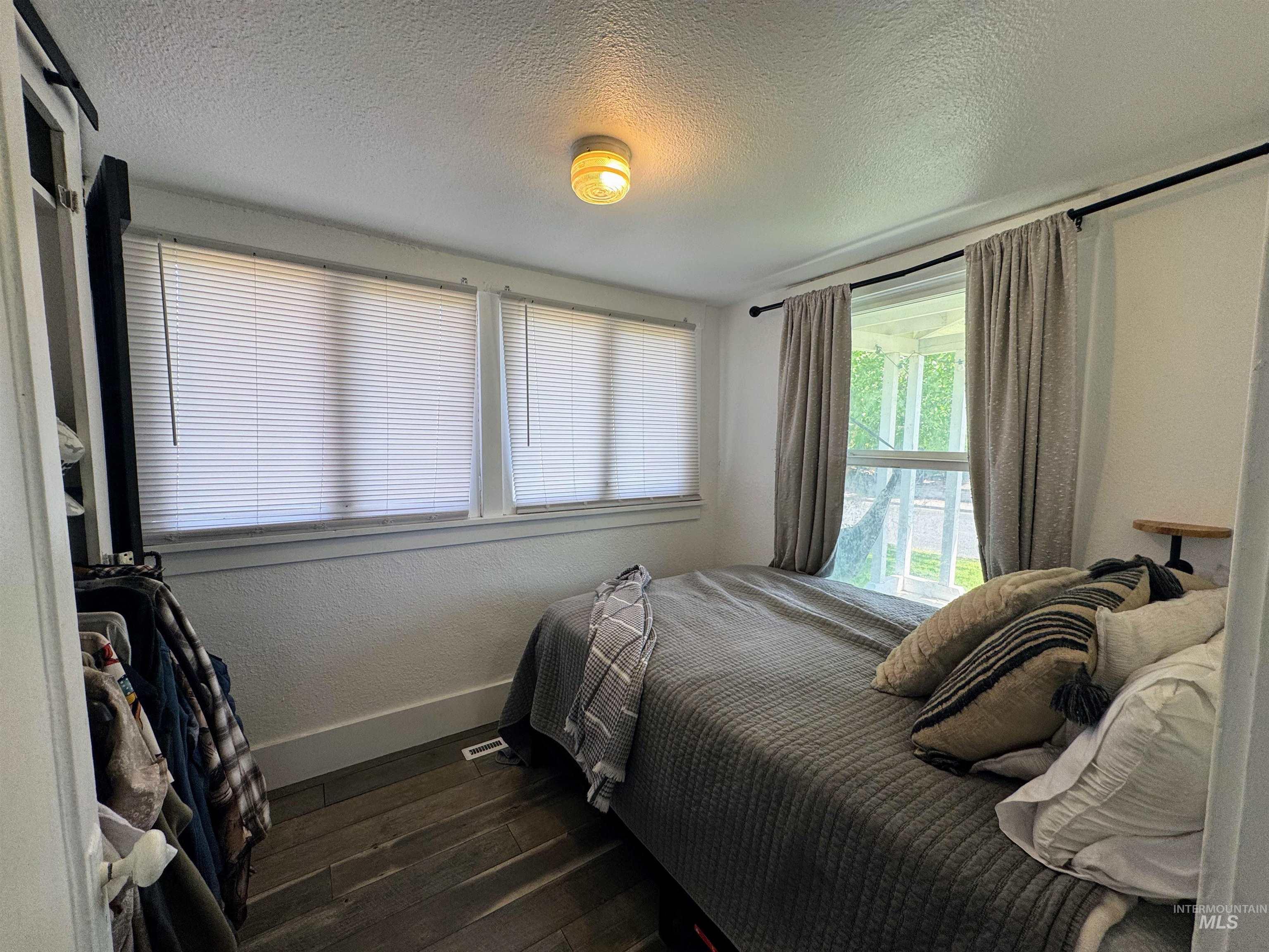 Bedroom featuring a textured ceiling and dark wood finished floors
