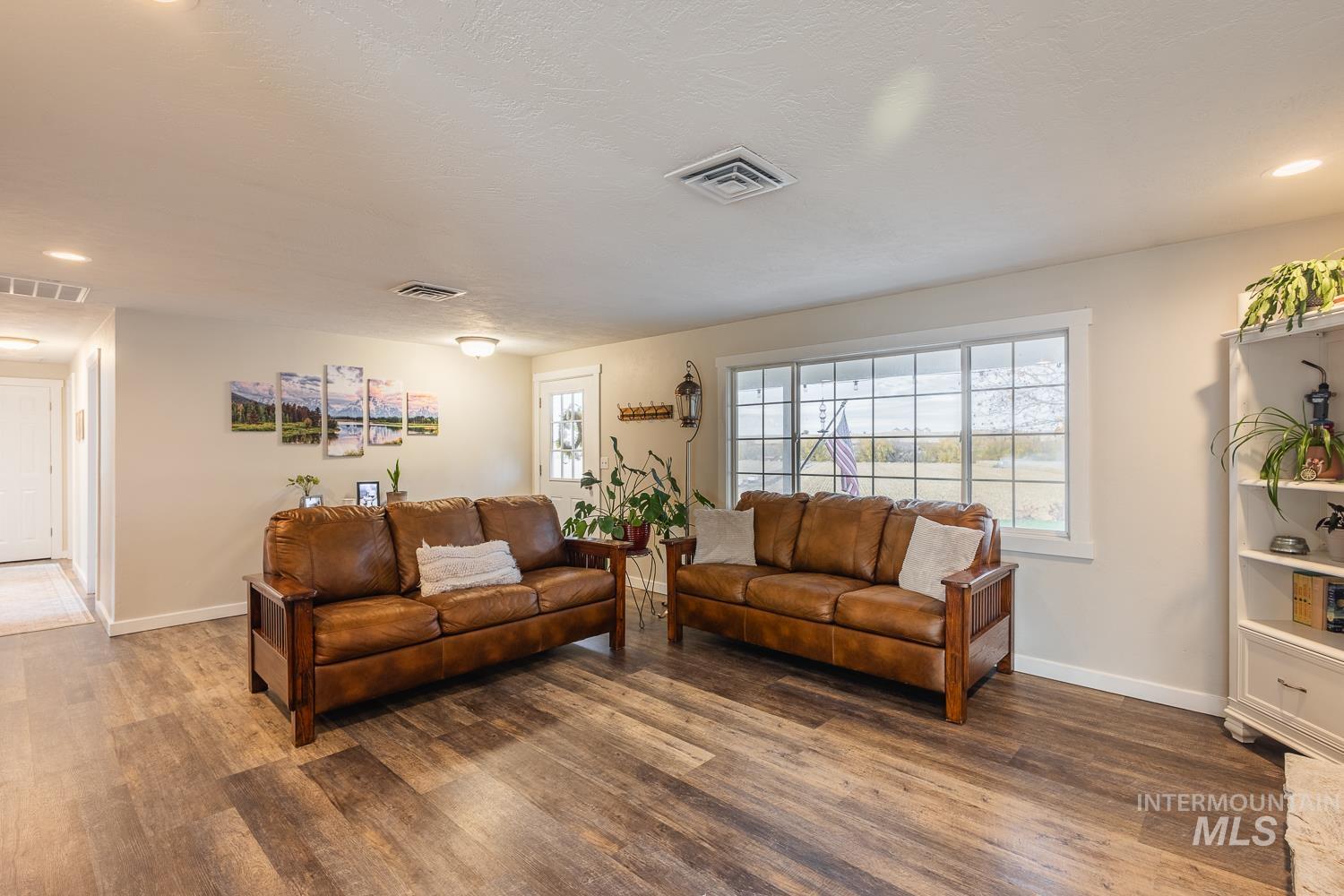 Living area with recessed lighting, wood finished floors, and a textured ceiling