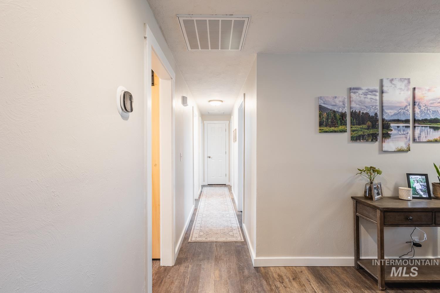 Hallway featuring dark wood-type flooring and baseboards