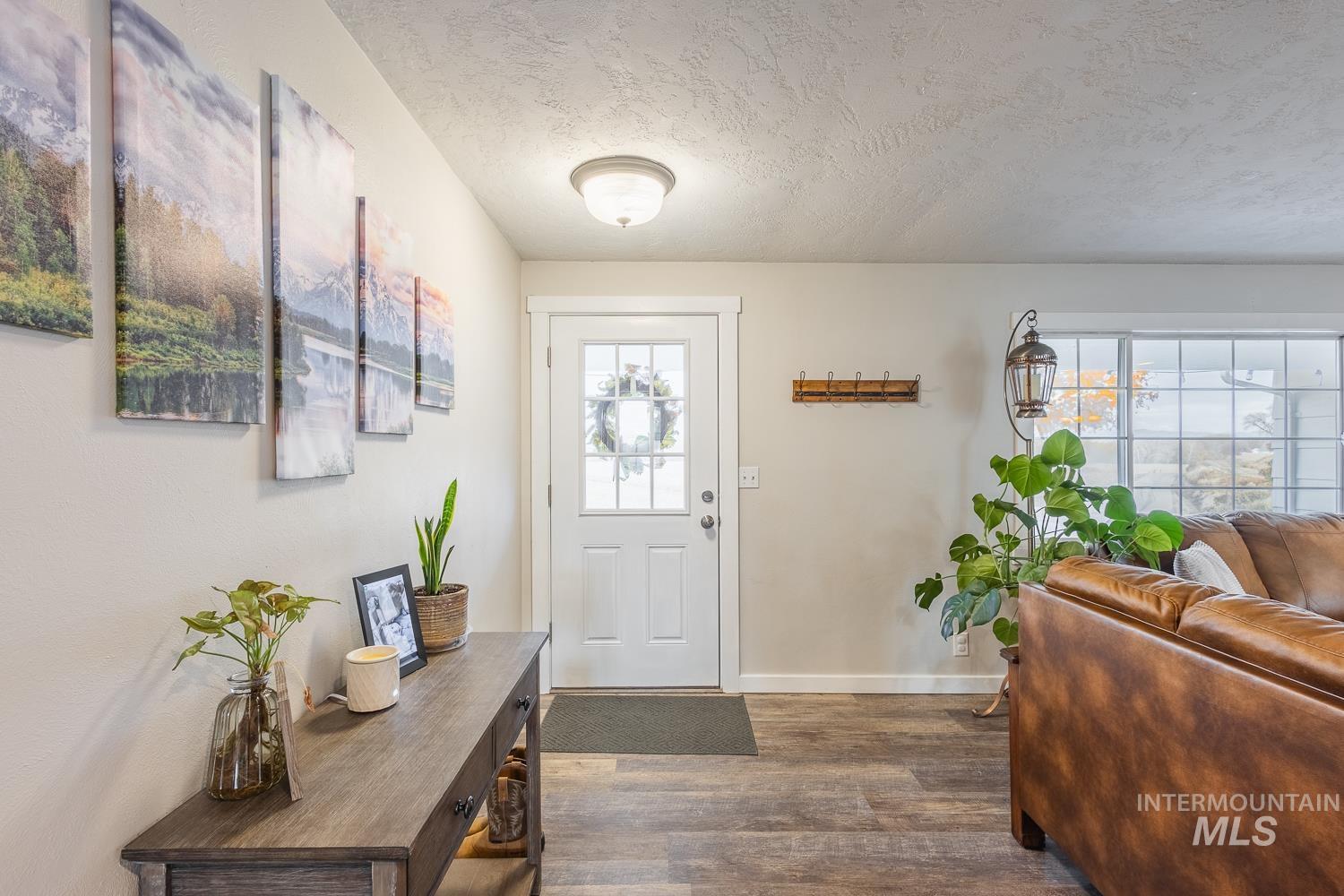 Foyer entrance with a textured ceiling and dark wood-style floors