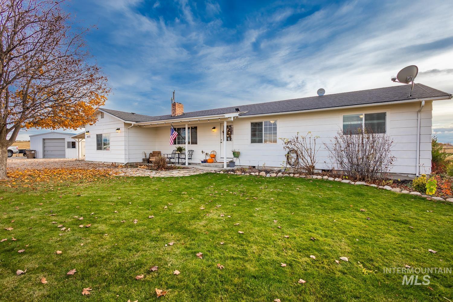 View of front of home featuring a front lawn, a chimney, and a patio area