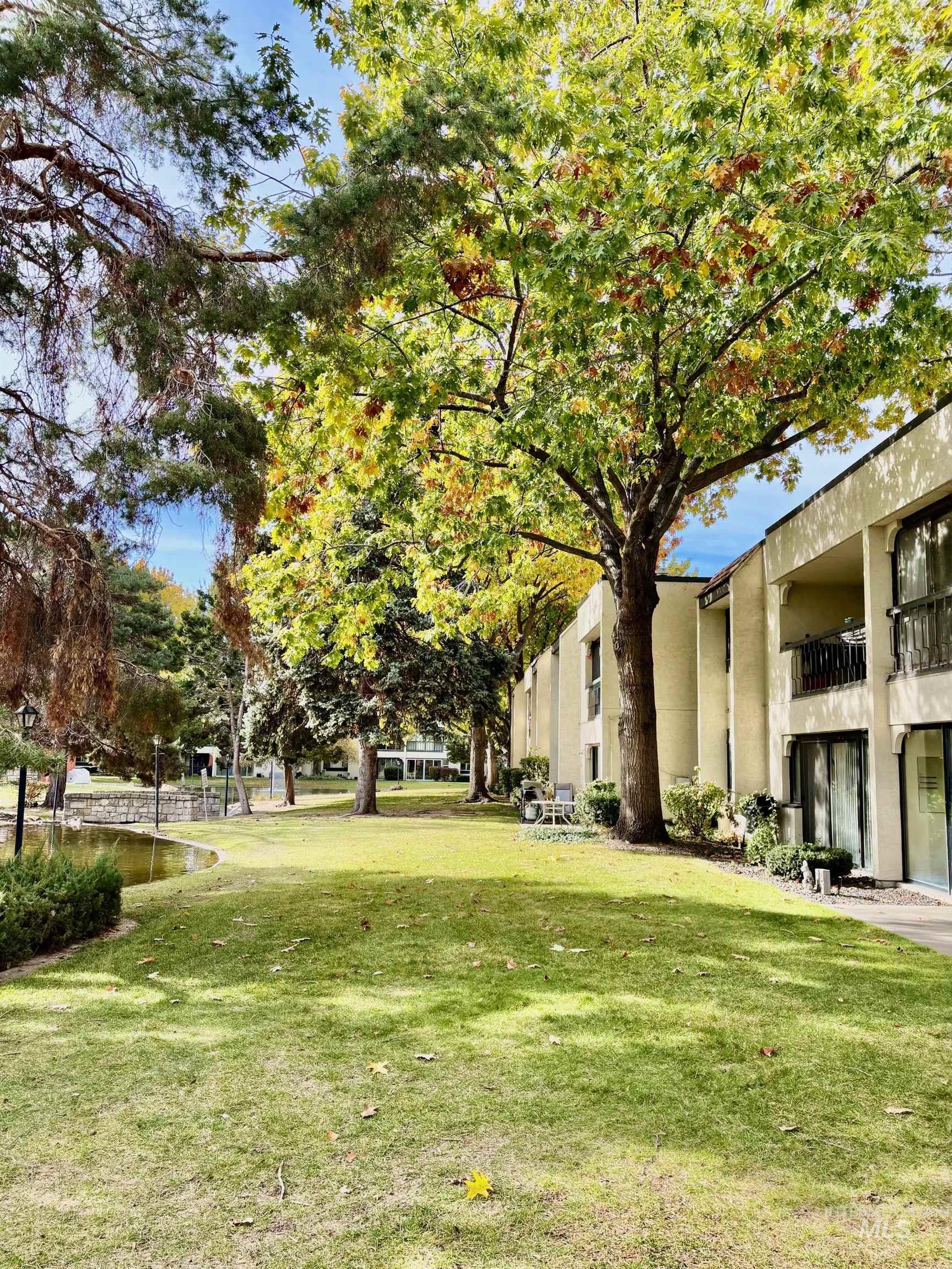 View of grassy yard featuring a balcony