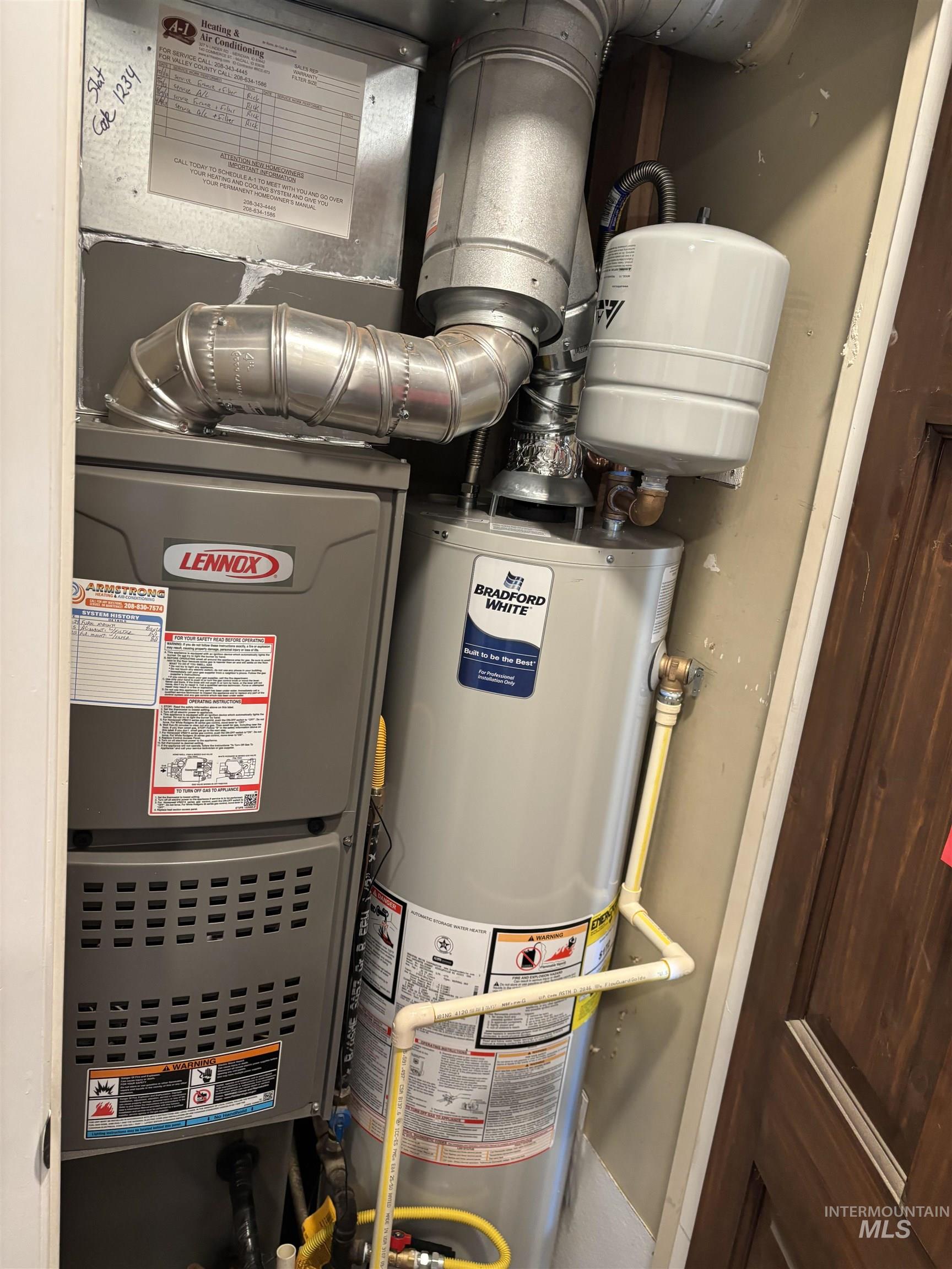 Utility room featuring water heater and heating unit