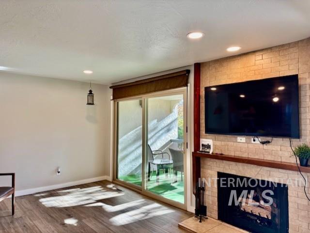 Unfurnished living room featuring dark wood-style flooring, a fireplace, and recessed lighting