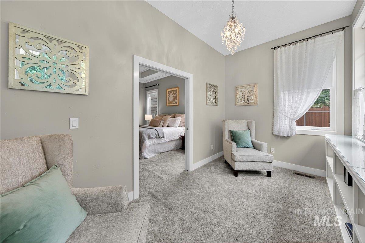 Living area with light colored carpet and a chandelier