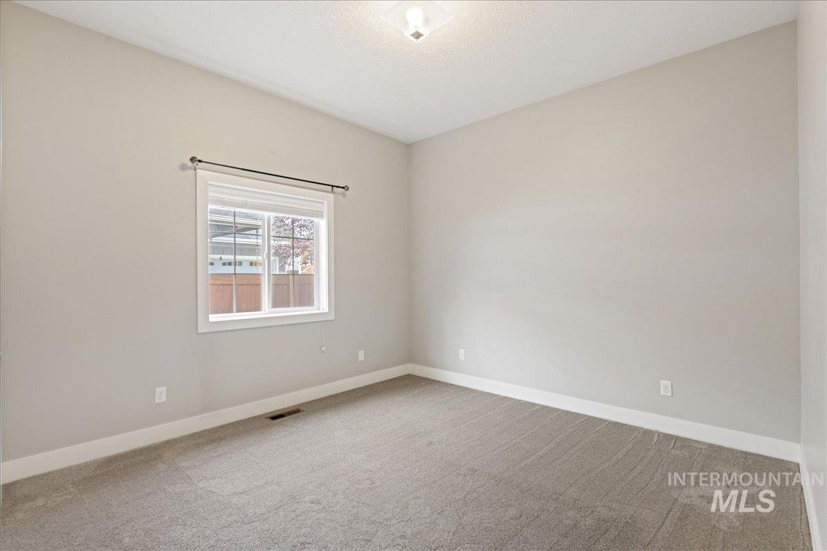 Empty room with light carpet and baseboards
