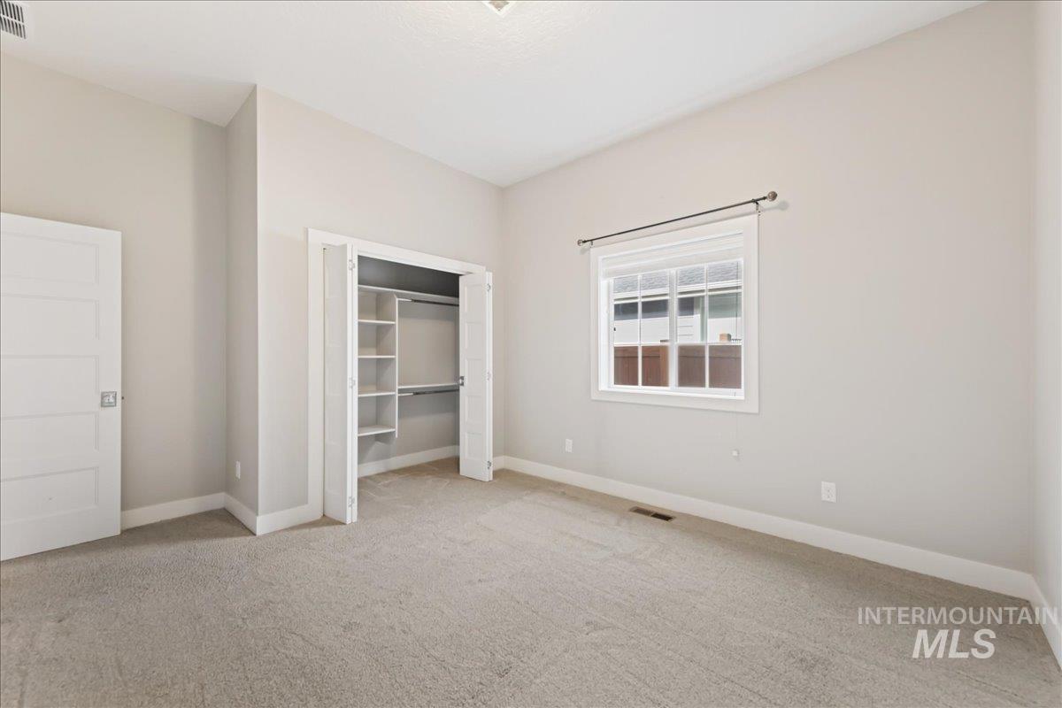Unfurnished bedroom with light colored carpet and a closet