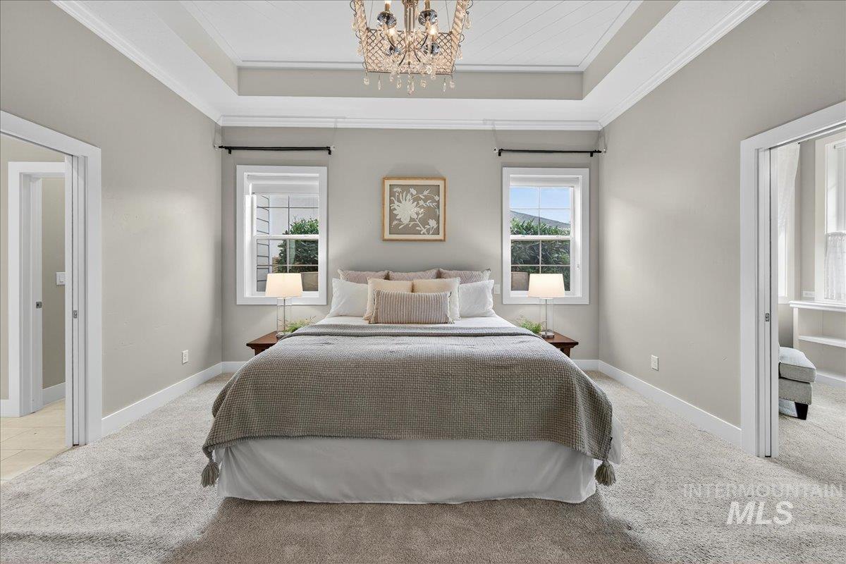 Bedroom with light carpet, a chandelier, and crown molding