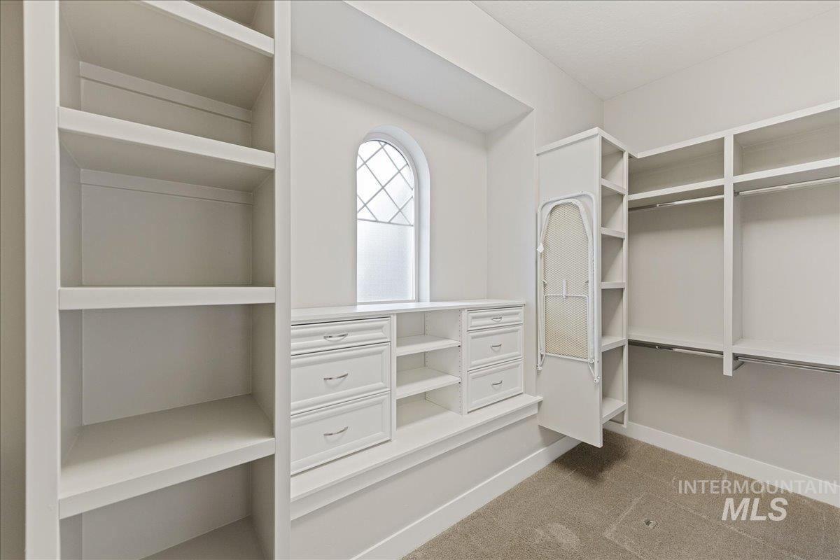 Spacious closet with light colored carpet
