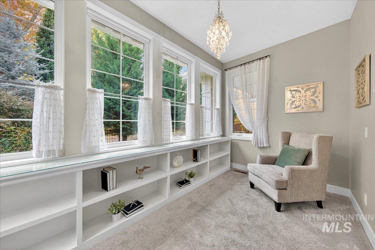 Sitting room with light carpet and a chandelier